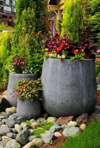 Backyard garden with stone pond and water feature by Classic Landscaping