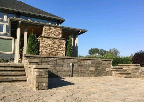 Stone patio outdoor living area in residential landscape by Classic Landscaping in Greater Seattle