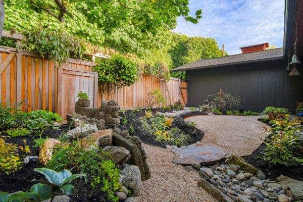 Contemporary plantings and natural stone hardscape in Japanese-inspired garden by Classic Landscaping