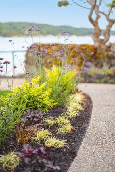 Lakefront Landscape featuring stone pathways and waterfront garden by Classic Landscaping