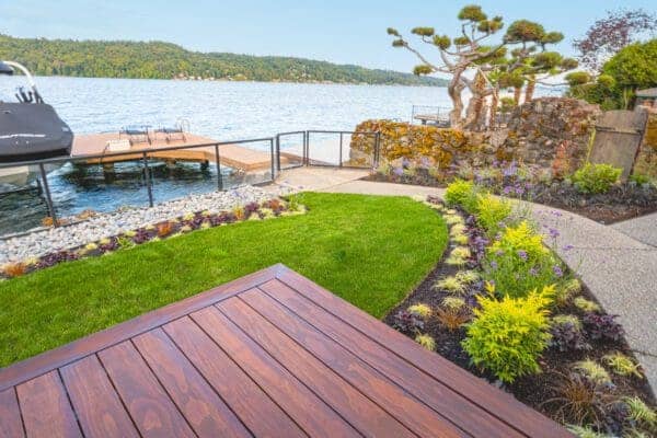 Lakefront Landscape featuring waterfront garden and mature trees by Classic Landscaping