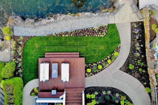 Lakefront Landscape featuring stone pathways and waterfront garden by Classic Landscaping