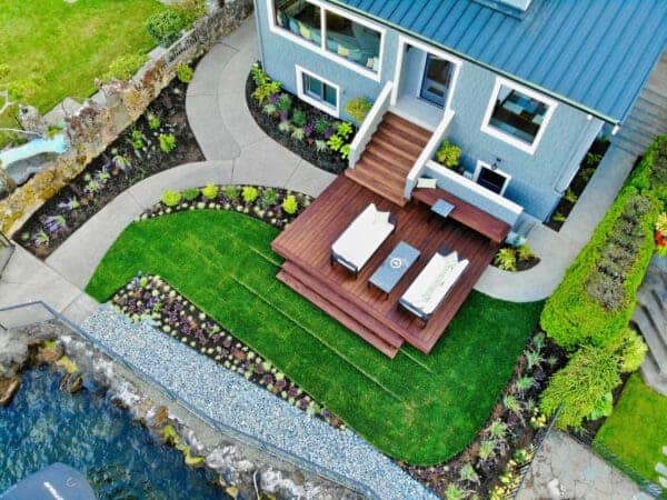 Lakefront Landscape featuring waterfront garden and mature trees by Classic Landscaping