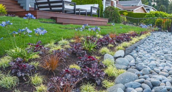 Lakefront Landscape featuring waterfront garden and mature trees by Classic Landscaping
