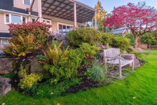 Peaceful lakeview garden with layered plantings and natural stone accents in Greater Seattle by Classic Landscaping