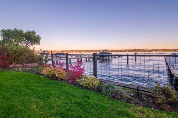 Garden pathway through lush plantings with serene lake views in Greater Seattle residential landscape design
